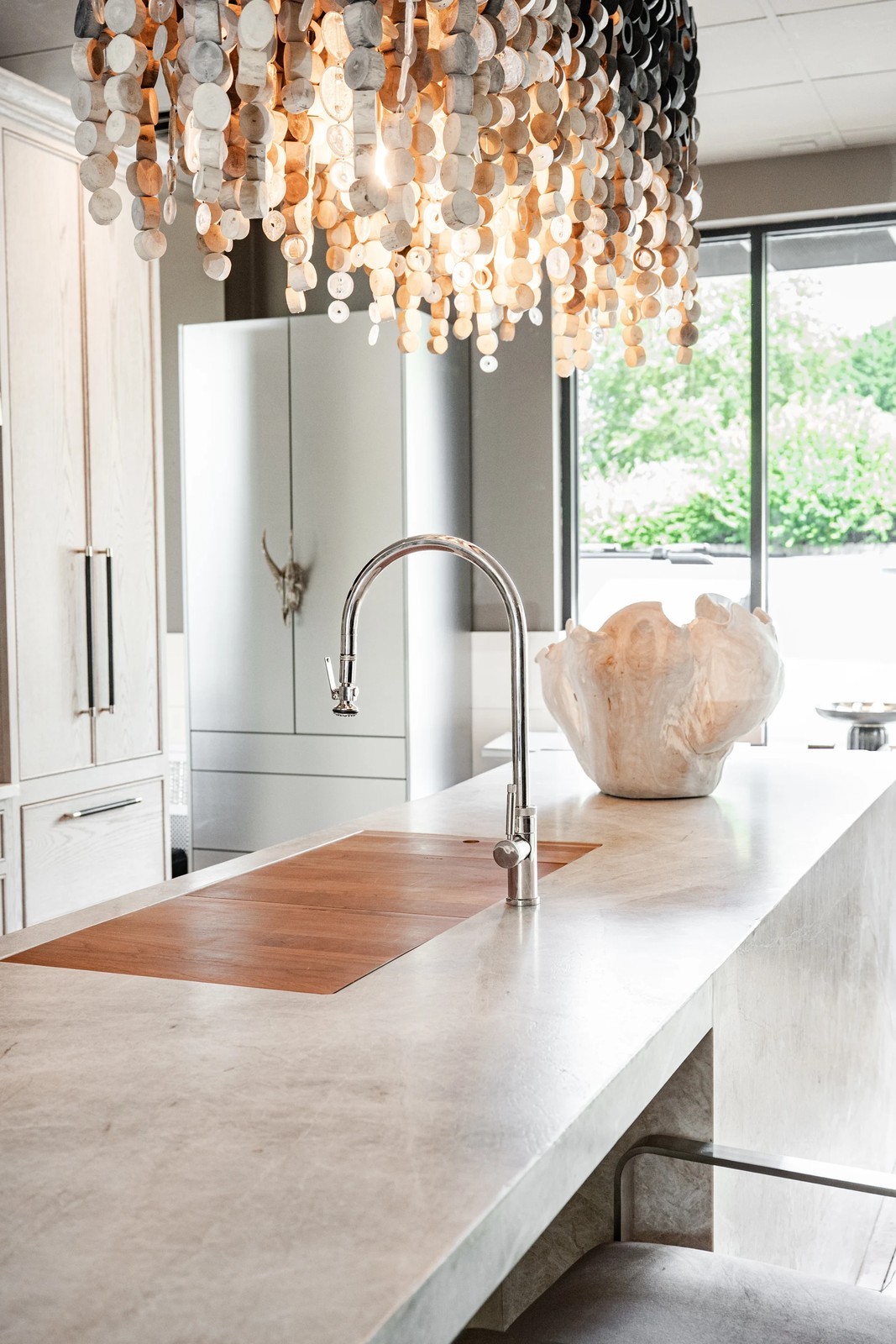 Cabinet & Stone Lab showroom with an island and sculptural chandelier